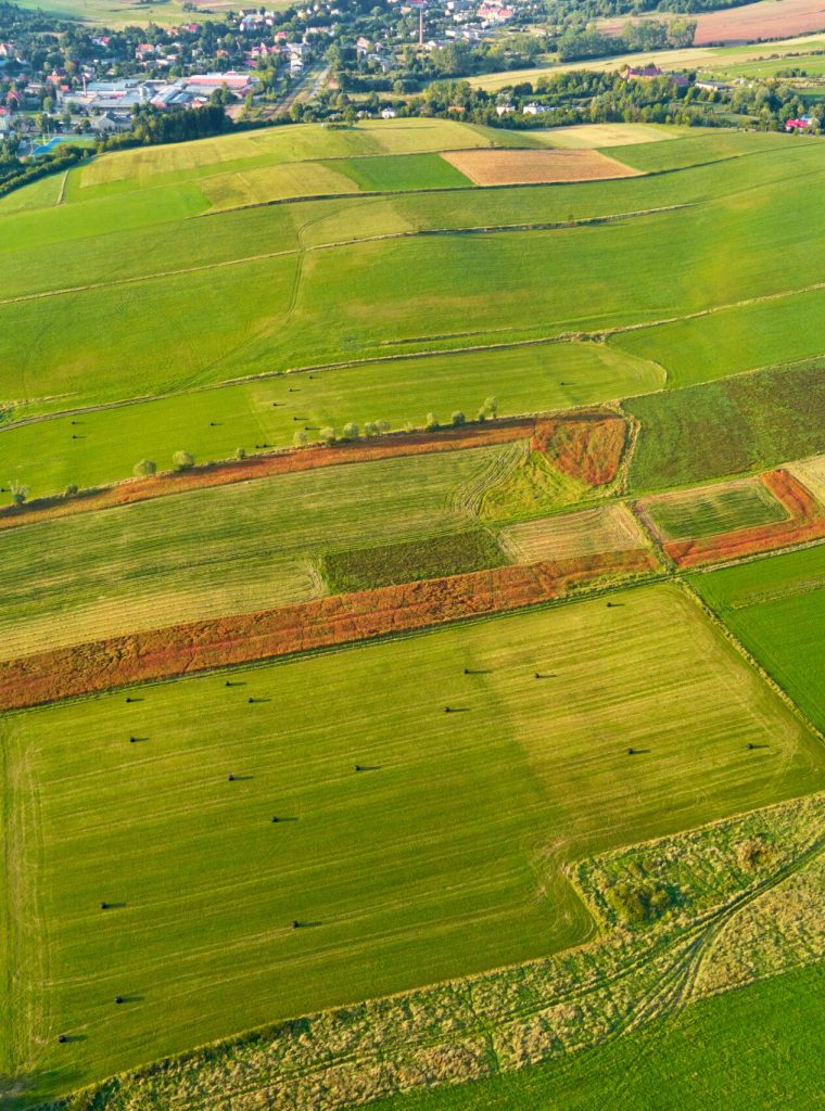 Aerial view of agricultural fields near small europe town. Countryside background. Nature landscape