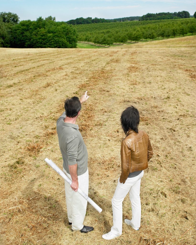 Architects discussing in a field