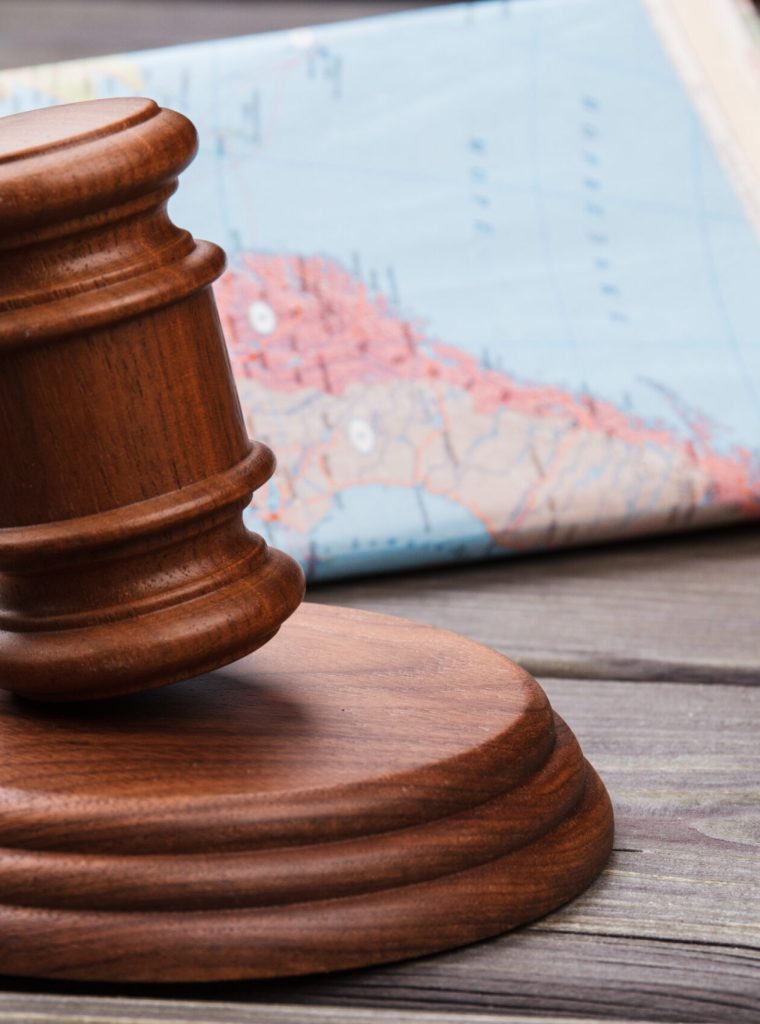 Judges gavel and colorful world map. International court concept.